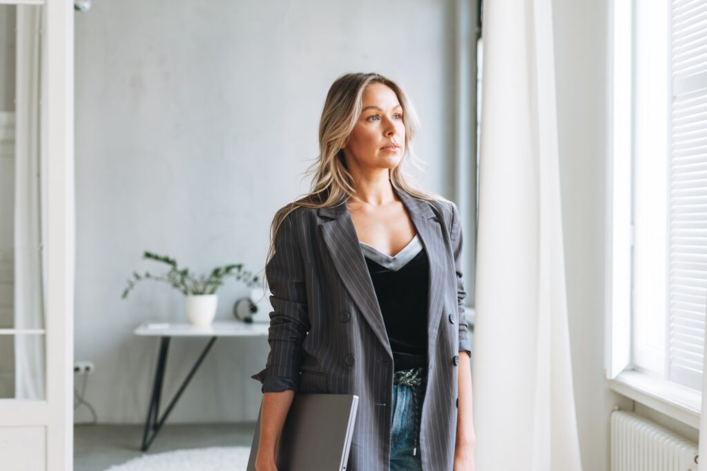 Blonde business woman working at laptop in modern office